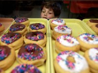 Zachary Aguiar, 6, takes a closer look at the chocolate frosted donuts at Ma's Donuts on Acushnet Avenue in the north end of New Bedford.   PETER PEREIRA/THE STANDARD-TIMES/SCMG